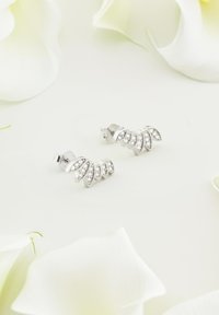 Söljearringar med fläktliknande design som har flera bladdformer, prydda med små klara ädelstenar, mot en ljus bakgrund.