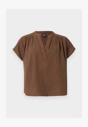 Καφέ βαμβακερό μπλουζάκι με κοντά μανίκια, V-λαιμόκοψη και λεπτομέρειες με πτυχώσεις στους ώμους, με ετικέτα GAP, απεικονίζεται σε απλό ανοιχτό φόντο.
