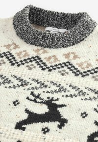 Breipul met een grijze geribde kraag, een crèmekleurige basis en een zwart rendierpatroon, met geometrische ontwerpen in bruin en zwart.