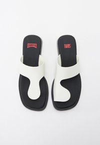 Vita lädersandaler med en unik utskärningsdesign, med en bred rem och en svart sula. "Camper" och "Twins" logotyper i röd.