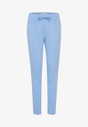 Pantalons de jogging bleu clair en tissu doux, avec une taille à cordon, deux poches avant et des jambes fuselées. Texture lisse et design décontracté.