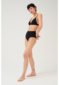 Set di bikini neri con bralette a collo a V profondo e slip a vita alta. Realizzato in materiale morbido con dettagli della fascia logo discreti.