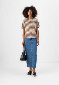 Brun og hvit stripete polo skjorte, blå denim maxi skjørt, svarte heler sandaler, holder en svart handveske. Glatt stoff og avslappet design.