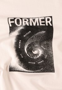Vit bomull t-shirt med en svart grafisk design som har ordet "FORMER" och ett spiralmönster, tillsammans med orden "MOTION" och "ALL KNOWN."