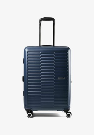 Marineblauer Hartschalenkoffer mit horizontalen Rillen, vier drehbaren Rollen, Teleskopgriff und seitlichen Griffen, Marke American Tourister.