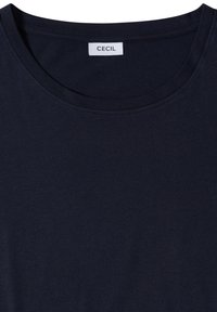 T-shirt bleu marine à col rond avec étiquette visible de la marque "CECIL" cousue à l’intérieur du col.