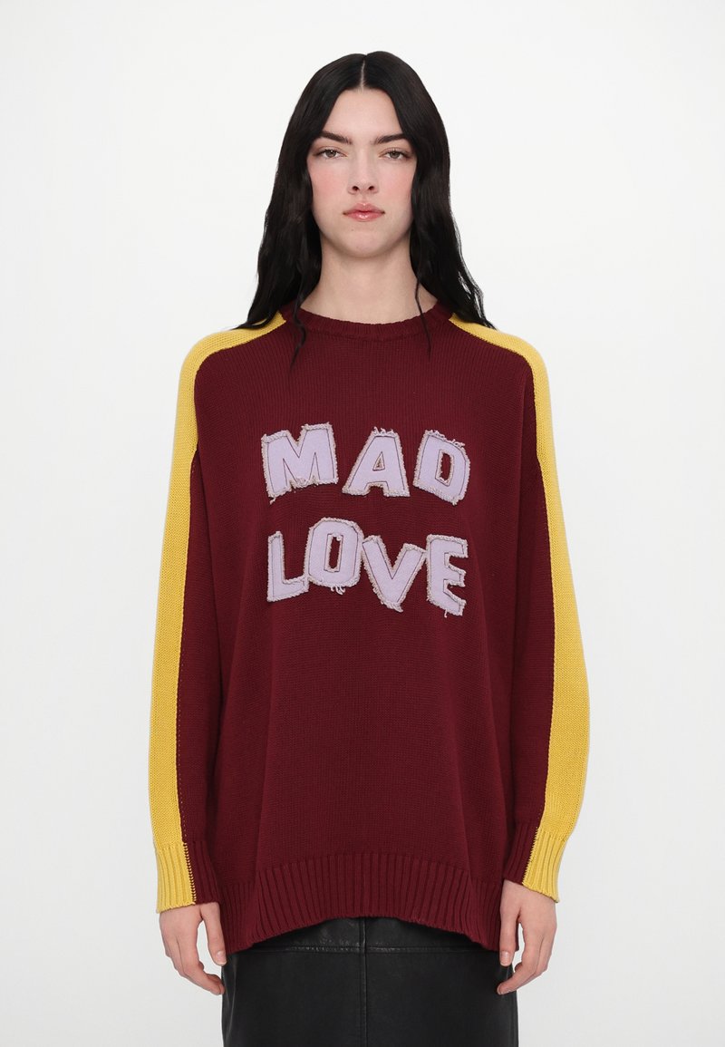 Maroon oversized sweater with yellow knit sleeves. Features "MAD LOVE" in purple embroidered letters, with a ribbed hem and cuffs.