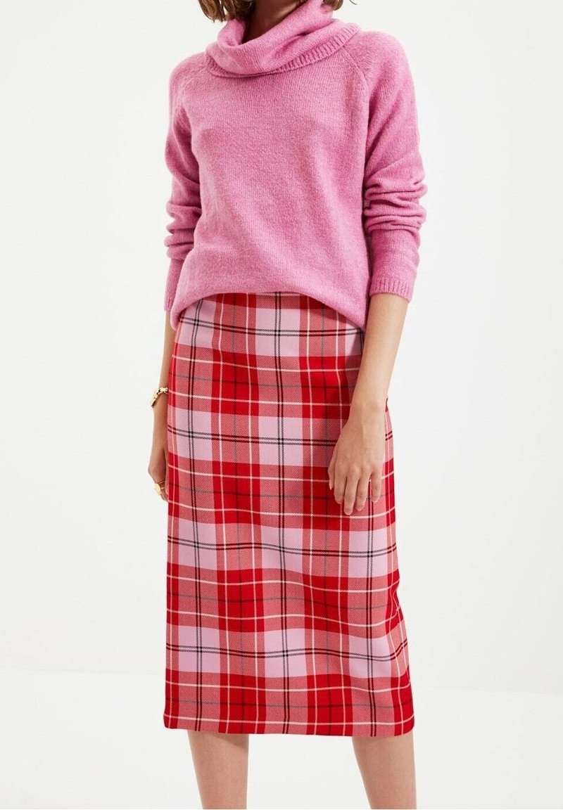 Rosa cowl-neck tröja och röd rutigt midikjol med rosa, röd och svarta detaljer, som har en mjuk textur och en figurnära silhuett.