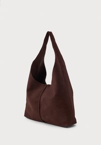 Bolsa de ombro em camurça castanha com um design curvado único, abertura ampla e uma textura suave. Apresenta uma única alça longa para transporte.