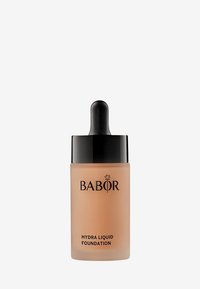 Flytande foundation i en glasflaska med ett svart pipettlock. Flaskan är frostad med en beige nyans och märkt "Babor Hydra Liquid Foundation."