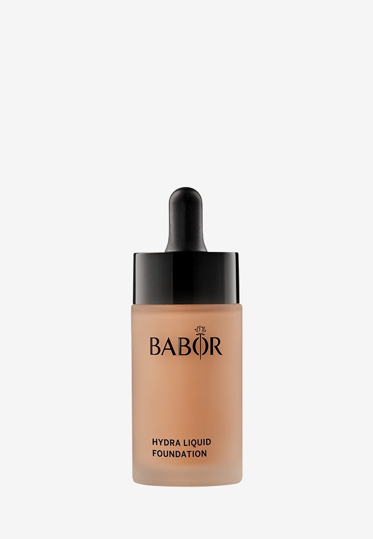Flytande foundation i en glasflaska med ett svart pipettlock. Flaskan är frostad med en beige nyans och märkt "Babor Hydra Liquid Foundation."
