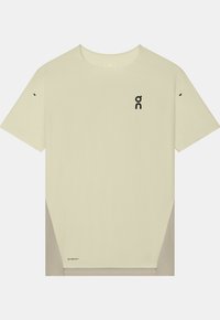 T-shirt de sport beige à manches courtes avec des panneaux latéraux gris et un petit logo noir sur la poitrine et près de l'ourlet inférieur.
