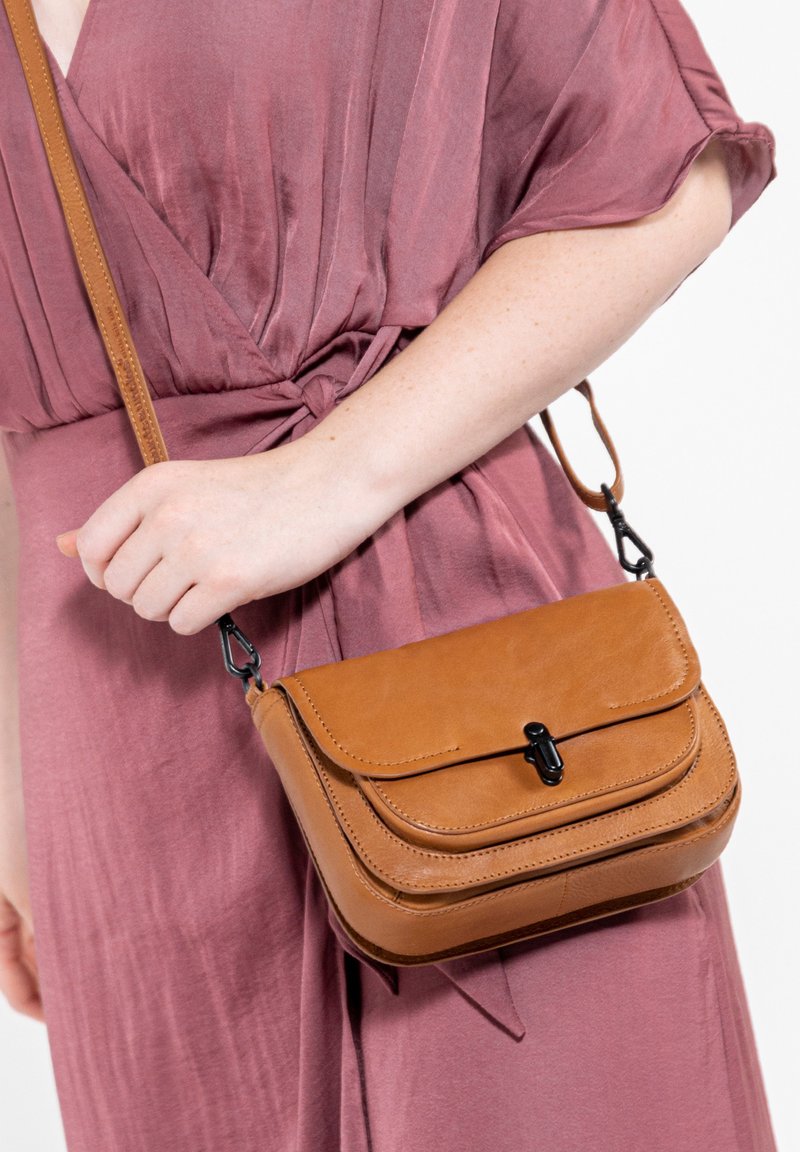 Borsa a tracolla in pelle marrone chiaro con due tasche frontali a patta, finitura opaca, tracolla regolabile e dettaglio in metallo nero.
