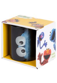 Tazza in ceramica nera con il volto blu di Cookie Monster, caratterizzato da grandi occhi bianchi, confezionata in una scatola stampata a colori con i personaggi di Sesame Street.