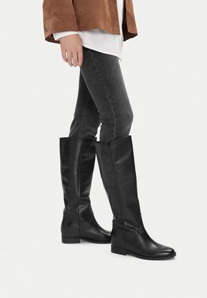 Schwarze knielange Stiefel aus glattem Leder mit runder Spitze und niedrigem Blockabsatz. Sie haben ein schlichtes, elegantes Design ohne Verzierungen.