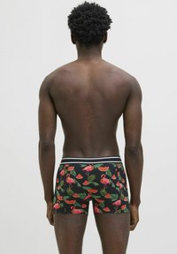 Boxer shorts neri con motivi colorati di fenicotteri e angurie, dotati di una vita in bianco e nero. Tessuto testurizzato con stampe vivaci.