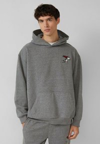 Grauer Hoodie aus Baumwollmischung, mit Kängurutasche, gerippten Bündchen und einem kleinen Snoopy-Design auf der linken Brust.