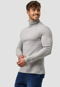 Szary sweter z golfem wykonany z miękkiego materiału, z długimi rękawami, dopasowanym krojem i małym logo na piersi.