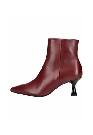 Stivale alla caviglia in pelle bordeaux con punta affusolata, texture liscia e un distintivo tacco conico nero. Chiusura con zip sul lato.