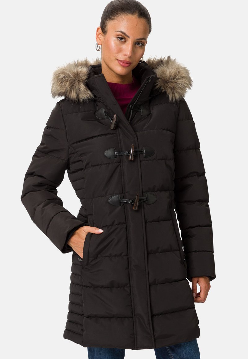 Svart puffjacka med huva i päls, stängningar med knyt, och ribbat mönster. Har framfickor och är knälång.