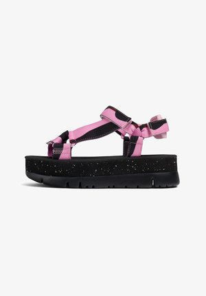 Sandali platform con suola nera puntinata e fascette in nylon rosa. Presentano fascette regolabili e una soletta imbottita per il massimo comfort.