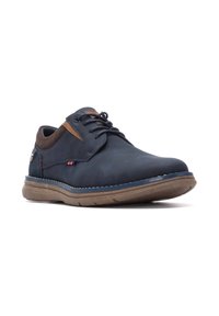 Zapato de cuero azul marino con cordones y detalles en gamuza marrón, suela de goma y costuras. Punta redondeada y diseño acolchado para mayor comodidad.