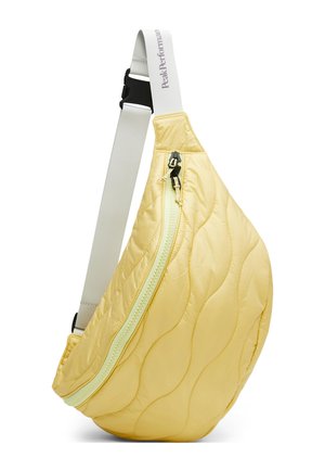 Gul quiltet crossbody-taske med buet lynlås og justerbar hvid rem med teksten "Peak Performance".