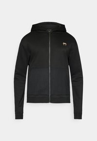 Μαύρο φούτερ με φερμουάρ και μπροστινή τσέπη, υφή από δίχτυ στο κάτω μέρος και μικρό λογότυπο στο πάνω αριστερό μέρος του στήθους. Ομαλό ύφασμα.