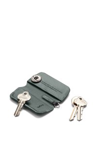 Étui à clés en cuir vert avec une finition texturée, doté d'une fermeture à bouton métallique et de trois clés visibles sur un porte-clés.