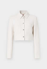 Veste blanche texturée coupée avec manches longues, fermeture à boutons sur le devant, col pointu et deux poches poitrine. Accents en matériel argenté.