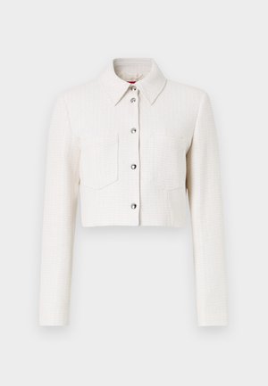 Iškirpta balta tekstūruota striukė su ilgomis rankovėmis, mygtukų priekinis uždarymas, smailas apykaklė ir dvi krūtinės kišenės. Sidabrinės spalvos detalės.