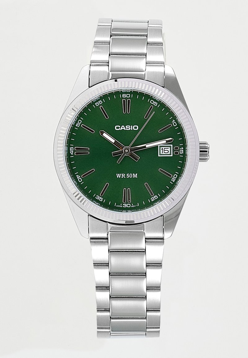 Montre-bracelet Casio argentée avec cadran vert, index des heures blancs, affichage de la date à 3 heures et bracelet en métal argenté.