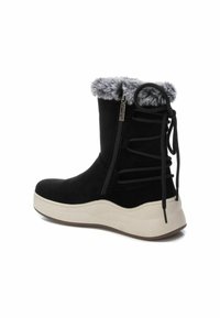 Stivale alla caviglia in suede nero con foderatura in pelliccia sintetica, zip laterale e dettagli decorativi in pizzo nero sul retro. Presenta una suola platform bianca.