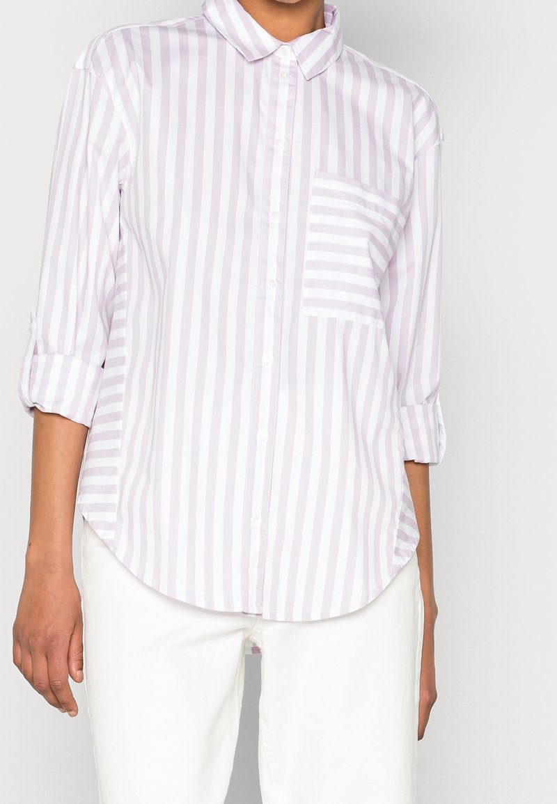 Chemise à rayures lavande et blanches, boutonnée, avec col, manches retroussables et poche poitrine, confectionnée en tissu léger.