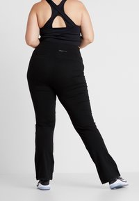 Černé sportovní legíny s vysokým pasem, rozšířeným střihem a pružným materiálem. Na zadní straně jemné logo. Vhodné pro aktivní nošení.