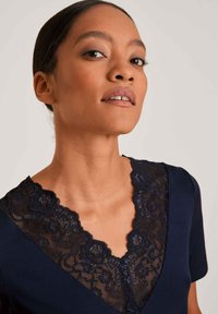 Abito corto navy a maniche corte con scollo a V profondo e dettagli in pizzo nero intricati, che offre una texture liscia e un design del colletto elegante.