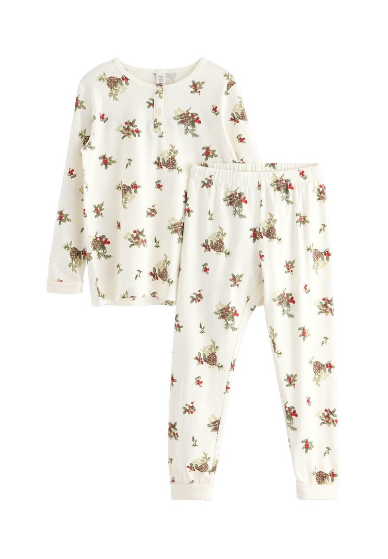 Ensemble de pyjama blanc comprenant un haut à manches longues et un pantalon. Les deux pièces sont ornées d'un motif floral, accentué de détails rouges et verts.