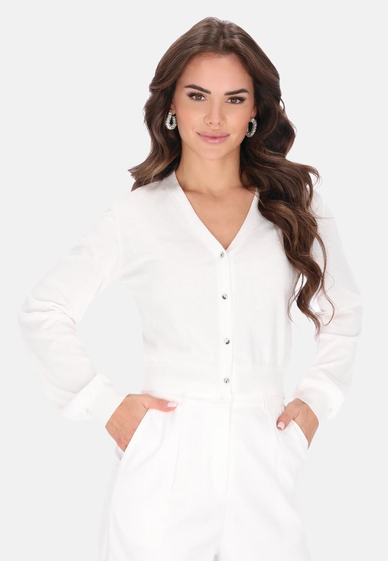 Cárdigan blanco de manga larga con escote en V y botones al frente. Hecho de material suave, presenta puños y cintura acanalados. Diseño simple.