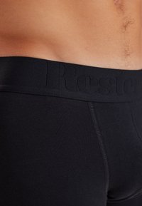 Sorte boxer shorts med en blød, elastisk talje, der viser et diskret prægede logo, med et glat, strækbart stof og detaljeret syning.