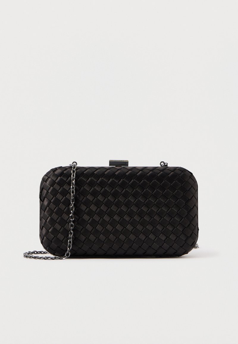 Pochette rectangulaire noire à texture tissée avec une bandoulière chaîne argentée sur un fond clair uni.