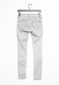 Jeans de mezclilla gris con un corte ajustado, colgando de un gancho negro. Incluye cinco bolsillos y una tela texturizada. Se muestra la vista trasera.