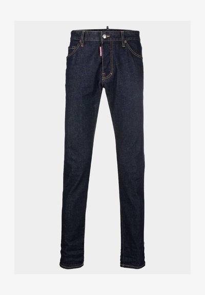 Tumedat sinised teksad, millel on kitsas lõige. Omab lukkudega hõlmavat, viit taskut ja kontrastset õmblust. Ei ole nähtavat kulumist ega kaunistusi.