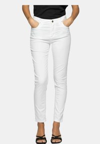Pantaloni bianchi slim fit in misto cotone, con tasche frontali e chiusura con zip e bottone. Texture liscia con un design elegante.