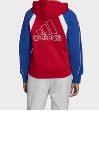 Sudadera con capucha roja y azul con acentos blancos, presentando el logo de Adidas en gran tamaño en la parte posterior. Tejido suave, puños y dobladillo acanalados.