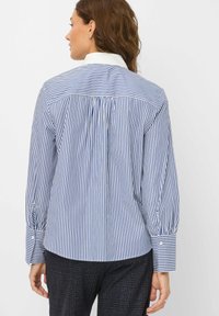 Stripet button-up skjorte i blå og hvid, med hvid krave, sammenfoldt ryg og lange ærmer med knapmanchetter.