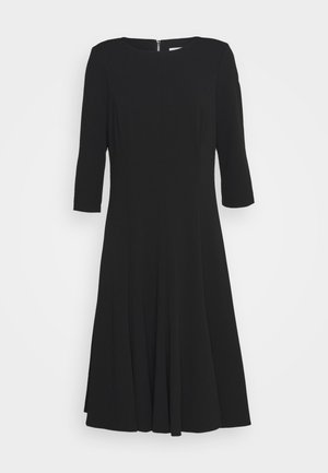 Black knee-length dress with three-quarter sleeves, round neckline, flared skirt, and back zipper closure.