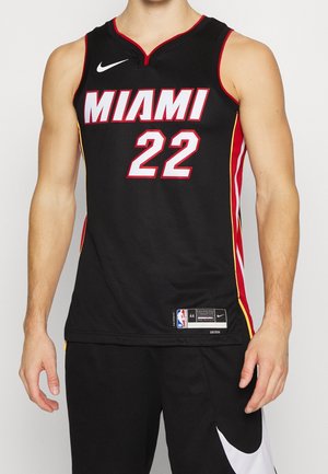 Męski tors w czarnej koszulce do koszykówki Miami z numerem 22 i czarnych szortach z białym znakiem Nike.
