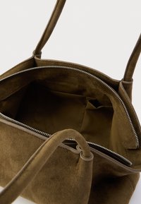 Smeđa antilop torba za nošenje s patentnim zatvaračem, mekanom teksturom, dva ručka i nenatkrivenim unutarnjim dijelom s malim džepom.