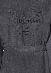 Grauem Frottee-Bademantel mit einem Bindegürtel, der ein geprägtes rundes Logo und ein Design einer Person mit ausgebreiteten Armen auf dem Rücken hat.