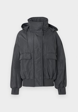 Veste matelassée courte gris foncé avec un col montant, une capuche amovible, deux poches avant, des poignets côtelés, et une finition lisse et texturée.